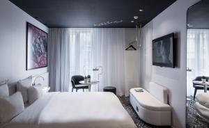 巴黎杰内若酒店的卧室配有一张白色大床和一张书桌