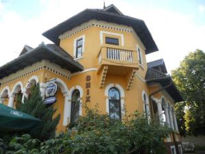 弗格拉什Pensiunea Onix的黄色房子的顶部设有阳台
