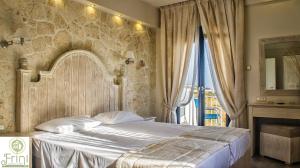 普洛马里翁弗里尼一室公寓的一间卧室设有一张带石墙的大床