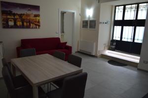 罗马毕&必公寓的客厅配有桌子和红色沙发