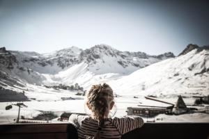 蒂涅避风港酒店的一位女人在山里望着雪覆盖的山