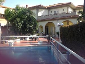 米斯泰尔比安科Hotel La Villa的一座房子前面设有游泳池