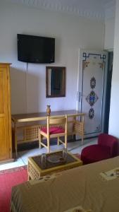 塔鲁丹特提奥特酒店的一间设有桌子和墙上电视的房间