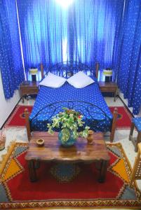 塔鲁丹特提奥特酒店的一间卧室配有一张带桌子和蓝色窗帘的床