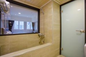 鱼池乡水沙连大饭店的浴室里设有玻璃门淋浴