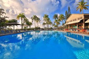 哥西尔拉克里奥尔海滩酒店及水疗中心的一座棕榈树大型游泳池和一座建筑
