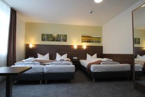 美因河畔法兰克福Goethe Conference Hotel by Trip Inn的酒店客房设有两张床和一张桌子。