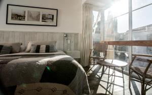 瓦尔帕莱索卡萨加洛斯阁楼酒店 的一间卧室设有一张床和一个大窗户