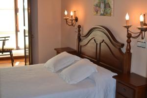 Barcenilla拉斯佩特斯旅馆的一间卧室配有一张带白色床单和两个枕头的床。
