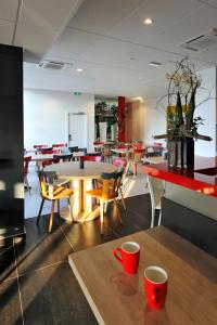 科尔马科尔马酒店 的用餐室,配有桌椅和红杯
