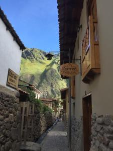 奥兰太坦波卡玛住宿加早餐旅馆的一条以山为背景的狭窄小巷