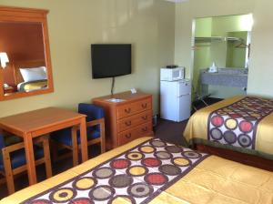 Pryor普赖尔美国最有价值旅馆的酒店客房设有两张床、一张桌子和一台电视。