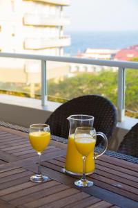 德班203 Oyster Quays - by Stay in Umhlanga的桌子上放两杯橙汁