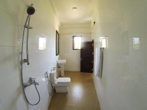 坦加拉隐居山林小屋的浴室配有卫生间、盥洗盆和淋浴。