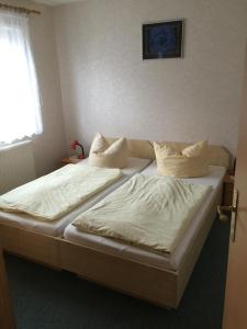 于克里茨Ferienwohnung Wede的一间卧室设有两张带白色床单的床和窗户。