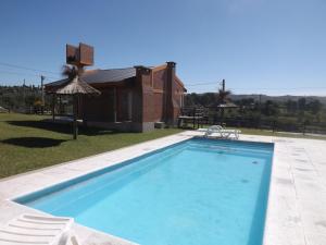 波特雷罗德加雷圣何塞度假屋的一座带房子的庭院内的游泳池