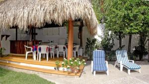 锡瓦塔塔内霍奔驰别墅酒店的庭院配有桌椅和草伞。