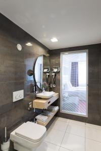 慕尼黑拜耳酒店的一间带卫生间、水槽和镜子的浴室