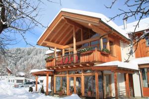 克查赫克恩顿州阿尔卑斯山营地酒店的木屋,在雪中设有阳台
