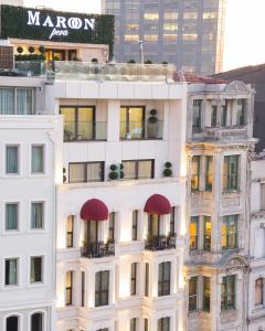 伊斯坦布尔佩拉栗色酒店的一座高大的白色建筑,上面有红色遮阳篷