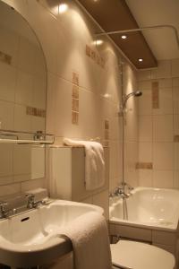 拉罗什-阿登克莱尔方丹国际之家酒店的浴室配有盥洗盆和浴缸。