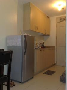 马尼拉爱丽舍城堡公寓式酒店的厨房配有不锈钢冰箱和橱柜