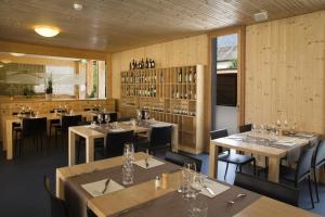FrascoFamilienhotel Campagna的餐厅拥有木墙和桌椅