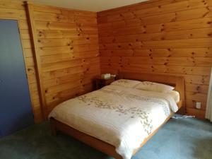 蚌贝Beaver Farm House的卧室配有木墙内的一张床