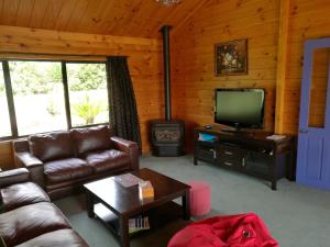 蚌贝Beaver Farm House的带沙发、电视和炉灶的客厅