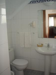 普拉亚达维多利亚Hotel Residencial Ermida dos Remédios的白色的浴室设有卫生间和水槽。