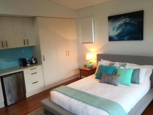 Valla Beach漂流公寓的一间卧室配有一张带蓝色和绿色枕头的床