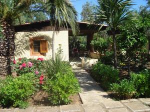 维耶斯泰Residence Giardino的花园,花园内有棕榈树和鲜花