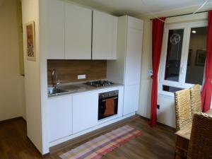 斯培西亚23号度假屋的厨房配有白色橱柜和水槽