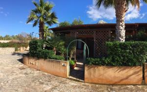圣维托罗卡波Acquamarina32的门前有门和棕榈树的房子