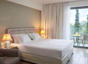 雅典艾默瑞莉雅酒店的一间带大床的卧室和一个阳台