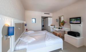 米多恩Calimera Yati Beach的卧室配有白色的床和电视。