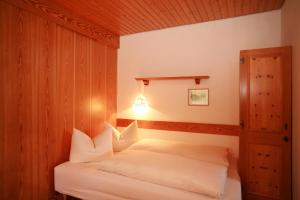 里茨勒恩亚希曼旅馆的一间卧室配有带白色枕头的床