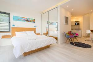 海法Eshkol Housing Haifa - Wallenberg Suites Complex的卧室配有一张白色大床和一张书桌