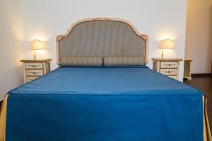 巴科利La Rada B&B的一张蓝色的床,配有两个床头柜和两盏灯