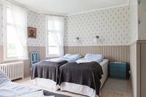 Lemland阿玛利亚酒店的一间卧室设有两张床和蓝色的橱柜