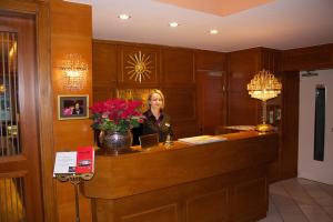 萨尔茨堡加雷兹提恩萨尔兹堡酒店的站在酒店房间接待台的女人