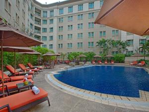 仰光仰光宾乐雅酒店的酒店设有带椅子和遮阳伞的游泳池