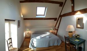 BaronLes Marronniers的一间卧室配有一张床、一张桌子和一个窗户。