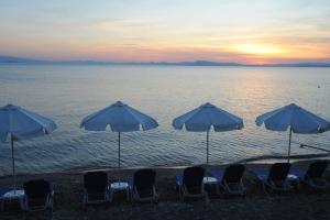 卡拉莫斯Symmetron Suites的海滩上的一组椅子和遮阳伞