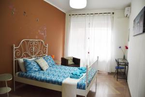 那不勒斯多莫斯布拉科公寓的一间卧室配有一张带蓝色床单的床和一扇窗户。
