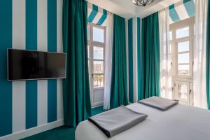 马拉加瓦莱里娅室友酒店的一间卧室设有一张带平面电视的床。
