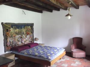 Brassempouy陶兹亚度假屋的卧室配有一张床,墙上挂有绘画作品