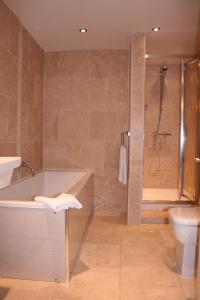马基特雷森阿德沃科特阿姆斯酒店的带浴缸、卫生间和淋浴的浴室。