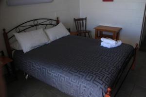 Lavers Hill奥特韦结汽车旅馆 的卧室配有1张床、1张桌子和1把椅子