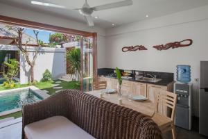 沙努尔两蜥蜴海滩别墅的厨房以及带桌子和沙发的客厅。